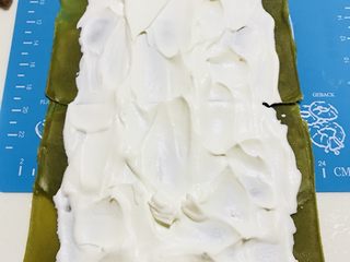 20、抹茶毛巾卷,冰箱拿出奶油,平铺在毛巾卷上面(四周都要留出一定的距离,不然卷起的时候,奶油会溢出来)
