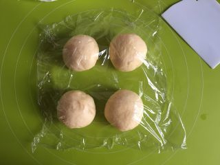 6、黄桃椰蓉心形面包,将面团均分为4个，揉圆，盖上保鲜膜松弛15分钟