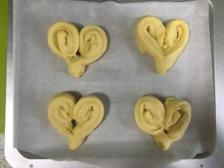 11、黄桃椰蓉心形面包,讲切好的面团，朝没有切段的方向往里卷起，如图