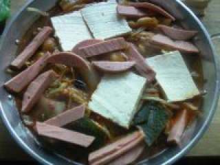 5、韩国部队火锅,放入豆腐、火腿、鱼丸等要涮的菜。