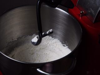 3、原味牛角面包,厨师机内放入高筋粉，盐和细砂糖，厨师机搅拌混合。