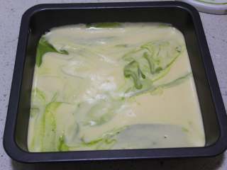 17、抹茶双色蛋糕卷,倒进烤盘，从20厘米高处，垂直的震两下烤盘，把大气泡震出来