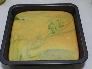 19、抹茶双色蛋糕卷,大概是12分钟时涨到最高，然后闻到香味，蛋糕体慢慢回落，上色。取出后立刻震两下，用脱模刀把四周划一下，倒扣脱模在油纸上，放在烤架上晾着，揭下底部的油纸（即毛巾面朝上）同时准备打发奶油（100克奶油+8克糖，喜甜的可以加10克，一般是10:1）