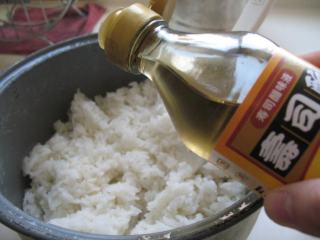 2、三文鱼寿司 ,趁热加入适量寿司醋，寿司醋与米饭的比例是1:6，加入寿司醋后，继续用饭铲搅拌均匀，放在一边晾凉，同时三文鱼洗净，吸干水分，切片备用