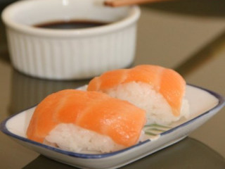 5、三文鱼寿司 ,攥好的醋饭成椭圆形。然后摆在盘子里。表面盖上一片三文鱼即可