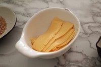 6、紫米芝士肉松饭团,把芝士片撕成小条。