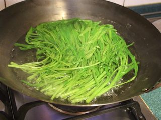 1、清烫空心菜佐黑芝麻酱,煮滚一锅水，加1小匙盐，将去根洗净的空心菜整株烫过约一分钟，捞起备用。