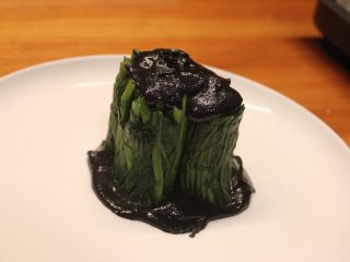 10、清烫空心菜佐黑芝麻酱,将成束的空心菜直立摆放在黑芝麻酱汁上，空心菜顶部再抹上一层黑芝麻酱。