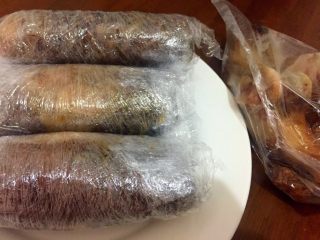 4、自制酱肘子,把煮好肘子分2半,骨头去掉,放保鲜膜和卷寿司一样卷紧实,一边卷一边拉紧保鲜膜。