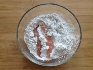 4、糖醋里脊,将腌制好的里脊肉条放到红薯淀粉里滚一圈,再拍掉多余的粉