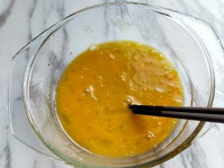 4、做饼＋美味的面条披萨饼,用筷子将鸡蛋打散。