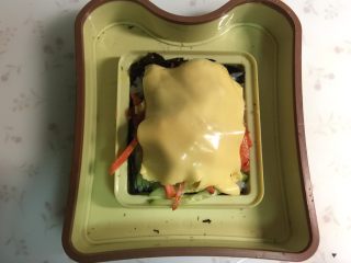 9、米饭三明治,盖上芝士片,芝士片切出比海苔略小一些的方块。