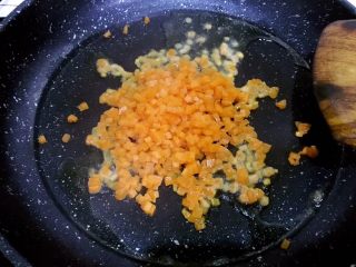 9、培根胡萝卜鸡蛋卷饭团,油热后倒入胡萝卜粒,翻炒