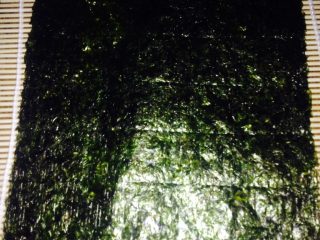 3、金枪鱼寿司,取一张海苔铺寿司帘上
