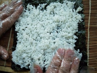 7、紫菜包饭,用手摊开，均匀即可。