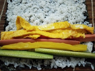 8、紫菜包饭,放入黄瓜，火腿肠，鸡蛋条。
