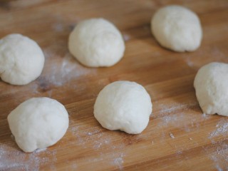 5、美式香肠热狗,取出面团反复按压排气，平均分成6个小面团，揉圆静置5分钟。