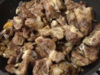 4、自制【少辣羊肉火锅】,羊肉倒入不沾锅内，开中火，加 姜片，柠檬皮（桔子皮，橙子皮也 可），香叶，尖椒，花椒，倒点料 酒，一起煸炒至焦香出油即可。