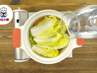 3、无添加蔬菜营养高汤,海带50g洗净,娃娃菜1颗撕开,西芹1段、胡萝卜1根切片,玉米半根切块,处理好的食材依次放入锅中,倒入清水没过食材