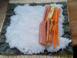 6、食寿司卷——剩米饭的华丽转身, 在米饭上铺上鸡蛋皮、胡萝卜、火腿肠