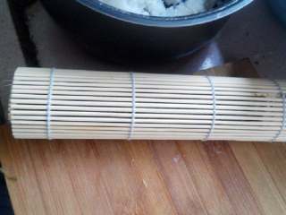 8、食寿司卷——剩米饭的华丽转身,顺势用竹帘将紫菜卷起;卷起后,用手紧握一分钟后打开