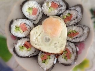 4、爱心❤️寿司,火腿条，黄瓜条放一侧抹上芥末卷好，切段去两头摆盘～OK啦！