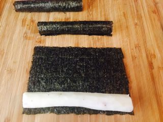 2、童趣寿司,买来的山药，基本都是这么长，蒸熟，马上把皮刨了。如果烫，可以冷开水冲一下，趁热刨皮。拿出寿司紫菜，一切二，我用剪刀剪。宽度同山药宽度。随后卷起来。卷好，放旁边备用。一个大卷要两个山药。