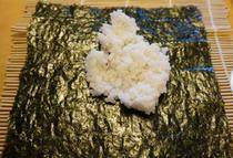 5、紫菜包饭,把寿司帘卷放在最底下，上面放一张紫菜，放上适量米饭