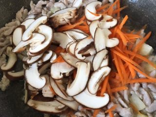 8、肉丝炒面,加入胡萝卜和香菇片翻炒均匀