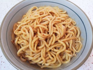 9、麻酱凉面,将准备好的麻酱凉面料汁加入面条里面搅拌均匀。
