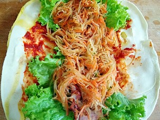 22、鸡蛋灌饼,再铺上炒好的醋溜土豆丝和胡萝卜丝。卷起来,切开就好。(饼小的话就不用切了,我这个饼比较大,我就切了一下。)