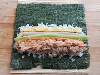 7、金顶寿司,在米饭上放上鸡蛋条，黄瓜，胡萝卜，火腿肠和肉松，在肉松上挤上适量的千岛酱