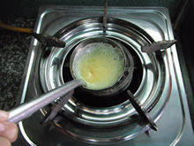 8、猪肉蛋饺,蛋皮表面开始凝固的时候，在蛋皮的一边加入适量猪肉馅，这时候会看到勺子边缘的蛋皮有点翘起来了，借助个小勺子把蛋皮盖过来。（图中我放了勺子）