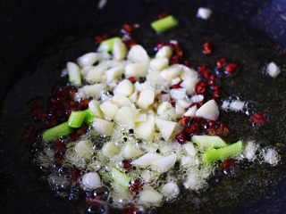 2、超级诱人无敌下饭的麻辣豆腐,倒入切碎的葱姜蒜末爆出香味