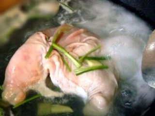 4、＃咸味# 健脾开胃的猪肚莲子汤,加姜片，适量料酒，葱下锅煮5分钟。