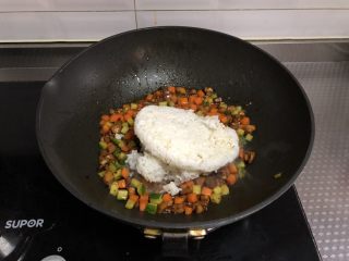 7、老干妈鸡丁炒饭,倒入隔夜剩饭，转小火，用铲子不停碾压翻炒至米饭无硬块