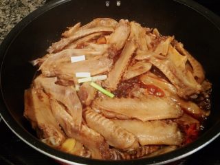 8、秘制酱鸭翅,「入啤酒」接着再倒入啤酒，再翻炒2分钟。现在下葱段，接着倒开水。