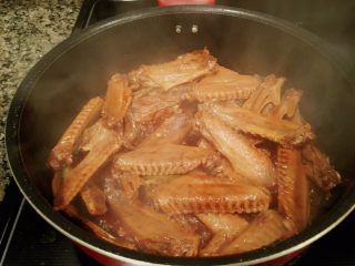 10、秘制酱鸭翅,「检查」水快煮干的时候，揭盖，骨头裸露出来基本就可以了。如果不把握，可以先尝一个，如果想要吃更软烂的鸭翅，可以重复第9步，再放入开水再煮一次。