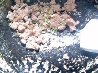 7、杂酱酸辣粉,肉末里放入适量的葱花翻炒。