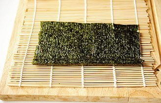 5、小花寿司,撤掉寿司帘，将多余海苔切掉；