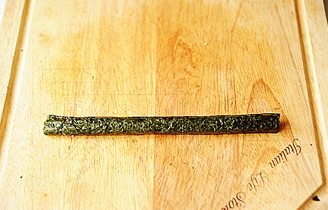 6、小花寿司,用手将卷好的小寿司卷掐紧，掐圆，形成一个花瓣；