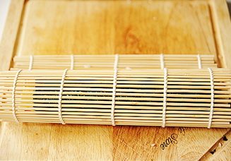 12、小花寿司,借助寿司帘，将其紧紧的卷起，收尾处的海苔若是翘起来，可以用沙拉酱作粘结剂，最后用沾了水的利刀切开即可。