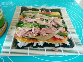 16、金枪鱼饭卷,将金枪鱼罐头打开，取20克左右的鱼肉，铺在最上面，撒上香葱花。