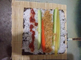 3、肉松寿司,将帘子平铺，拿一张海苔放在帘子上，放米饭、调味萝卜、胡萝卜、黄瓜、肉松！根据自己的口味放入酱（番茄酱、沙拉酱、鱼子酱……）