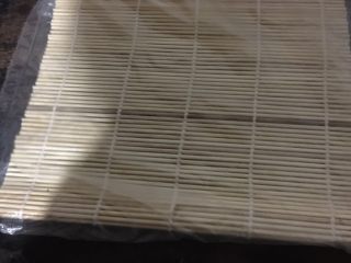 5、小米寿司,准备好卷帘,铺上保鲜膜或者保鲜袋