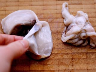 2、什锦海鲜寿喜锅,用手撕去墨鱼的褐色表皮、如图