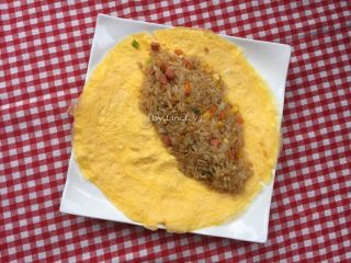 17、蛋包饭,将炒饭放置蛋皮的一半位置，注意边缘位置留空，用勺子轻压实