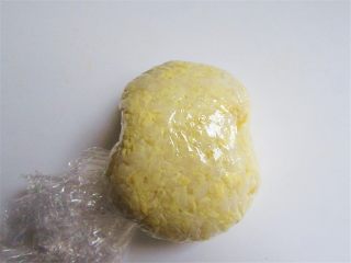 5、维尼熊便当,用双层保鲜膜把拌好的蛋黄饭包起来团一团再捏整形整出维尼熊的头部大概形状,再去掉保鲜膜即可,并用同样方法捏出两个耳朵
