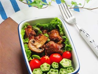 8、维尼熊便当,先取一个便当盒把做好的菜配上小西红柿和稍微焯水过的秋葵,按照自己喜欢的方式平铺好,我是在下面先把鸡肉蘑菇摆好后上面再用一层好看的西红柿秋葵做