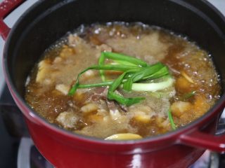 11、胡萝卜炖牛腩,转入炖锅中，大火烧开，放入葱结